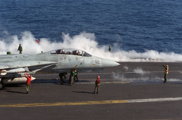 Flight deck crewmen prepare a Fighter Squadron 211 (VF-211) F-14A ...