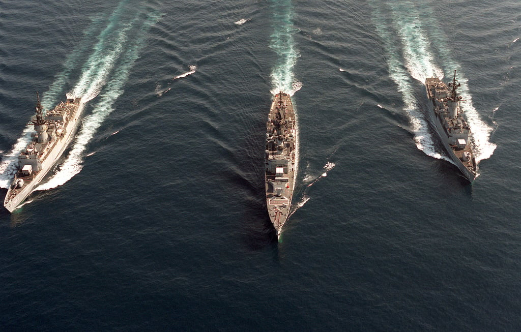 An aerial bow view of the frigate USS STEIN (FF-1065), left, the guided ...