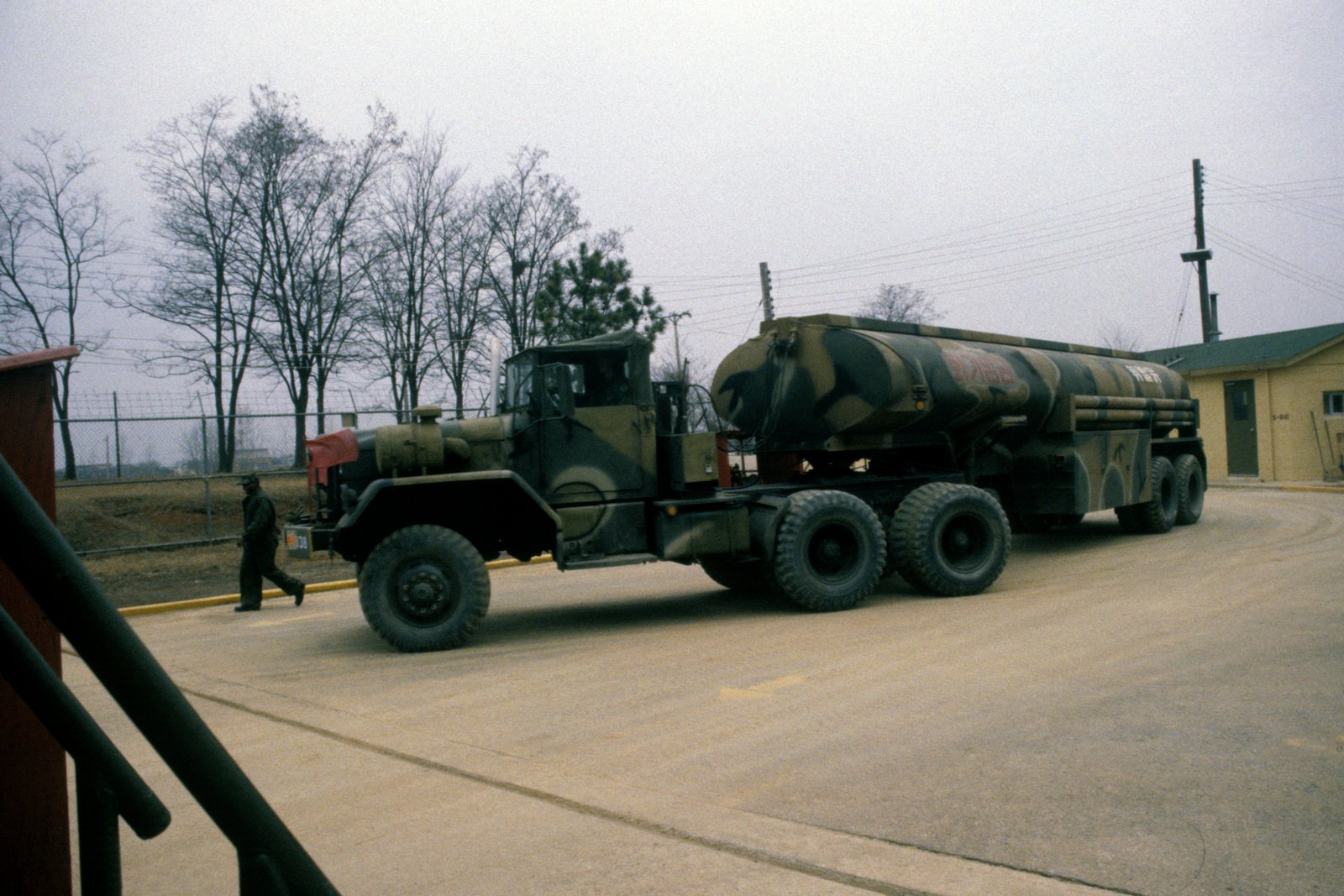 An M52A1 5-ton tractor truck departs from the bulk fuel point towing