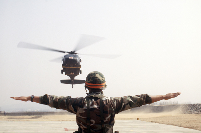 A UH-60 Black Hawk (Blackhawk) medical evacuation helicopter is guided ...