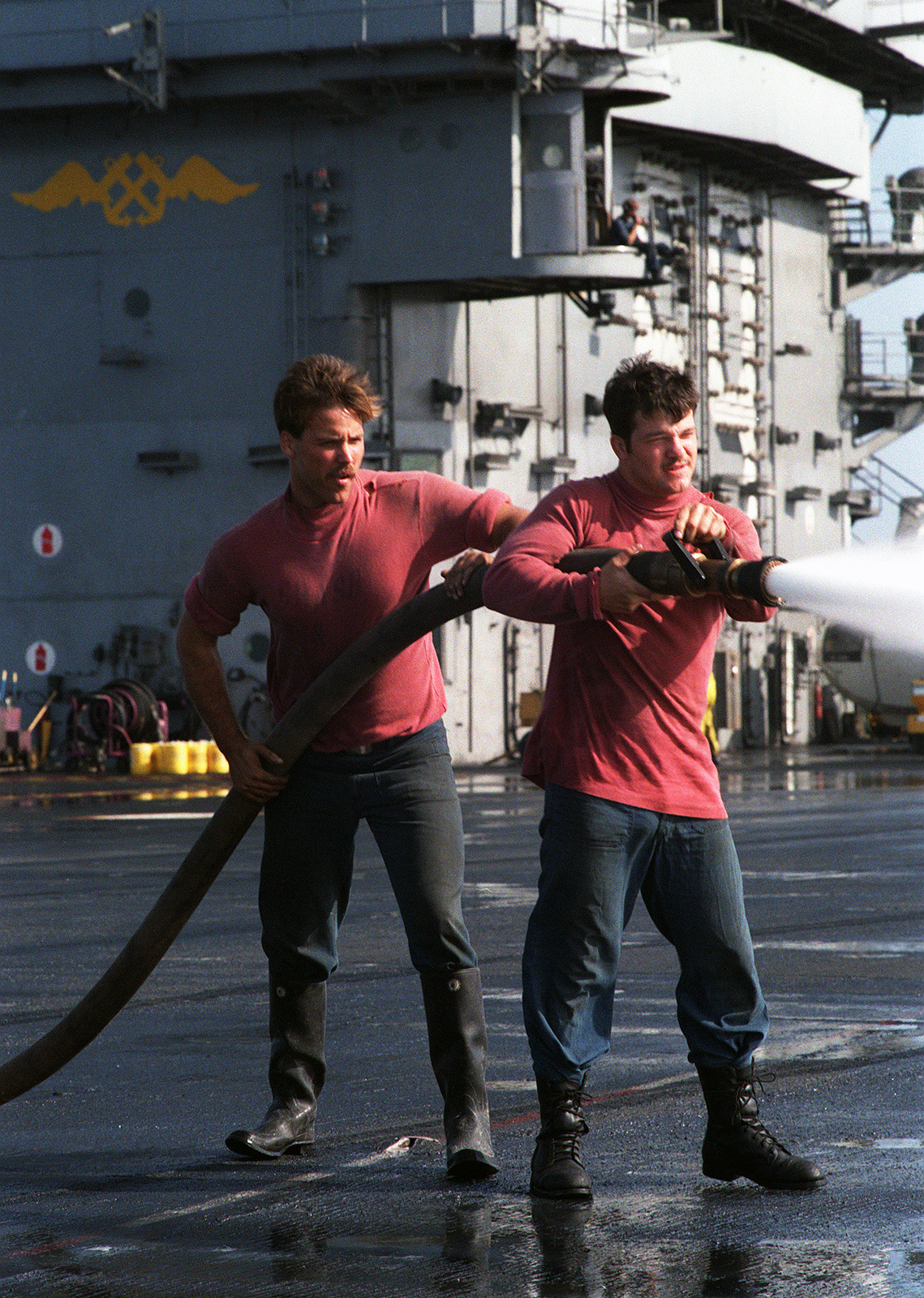 crew-members-rinse-aqueous-film-forming-foam-afff-from-the-deck-of