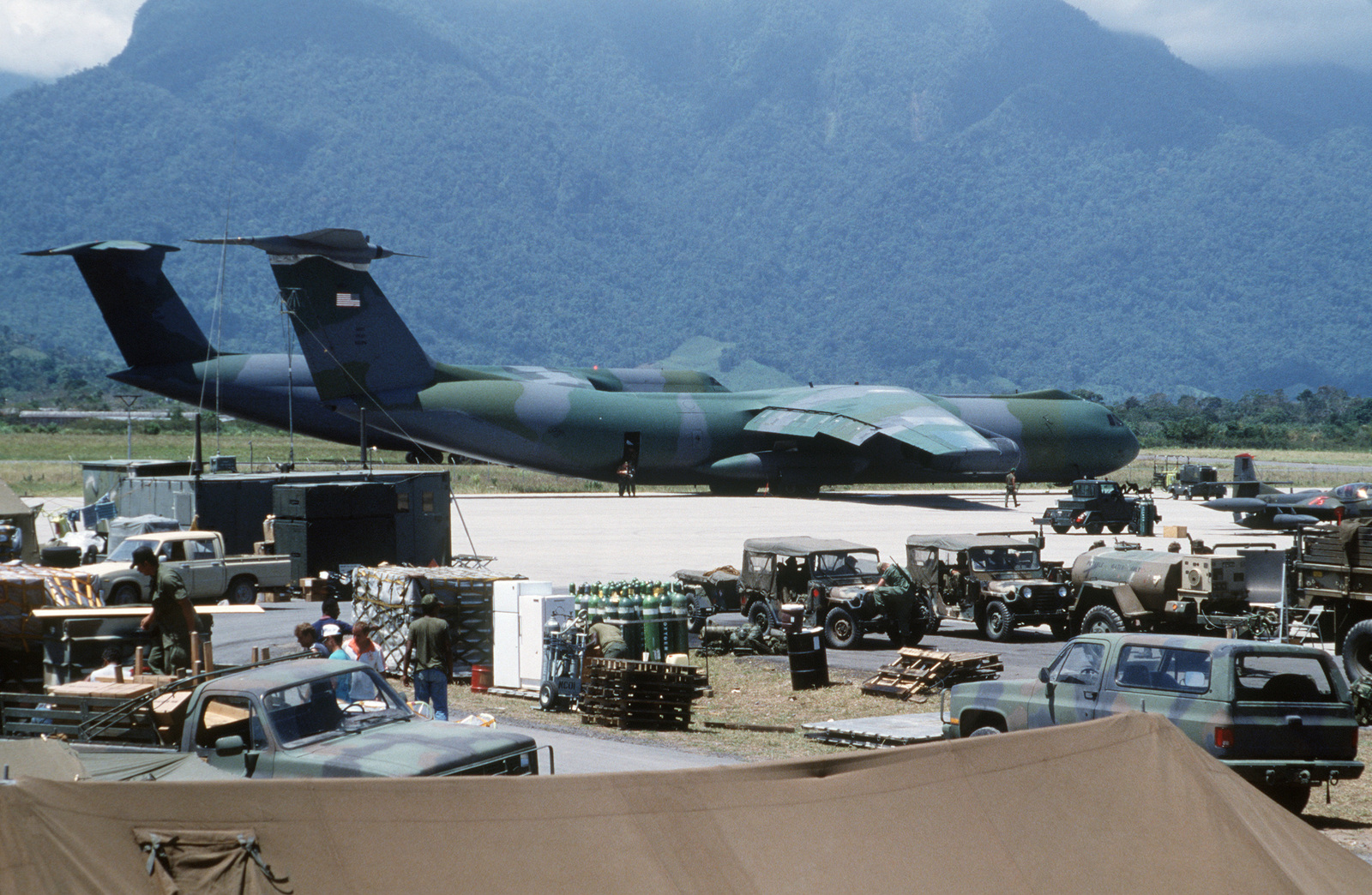 Vehicles And Other Equipment Are Staged For Loading Aboard C-141B ...