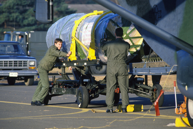 Members of the 10th Military Airlift Squadron load an F-100 aircraft ...