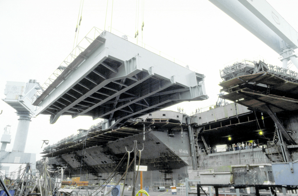 The No. 4 elevator is lifted into position on the port side of the nuclear-powered aircraft carrier USS ABRAHAM LINCOLN (CVN-72) during the ship's construction at Newport News Shipbuilding - PICRYL -