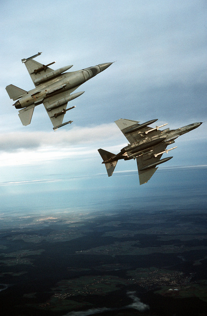 An air-to-air underside view of an F-16C Fighting Falcon aircraft and ...