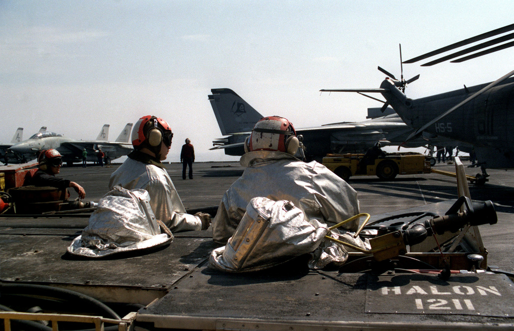 Two Firefighters Stand By On Their P-16 Shipboard Firefighting And ...