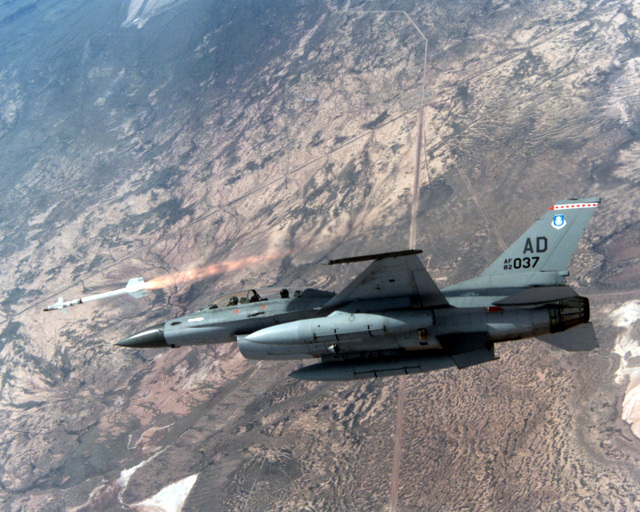 An F-16 Fighting Falcon aircraft fires an AIM-9P4 Sidewinder missile at ...