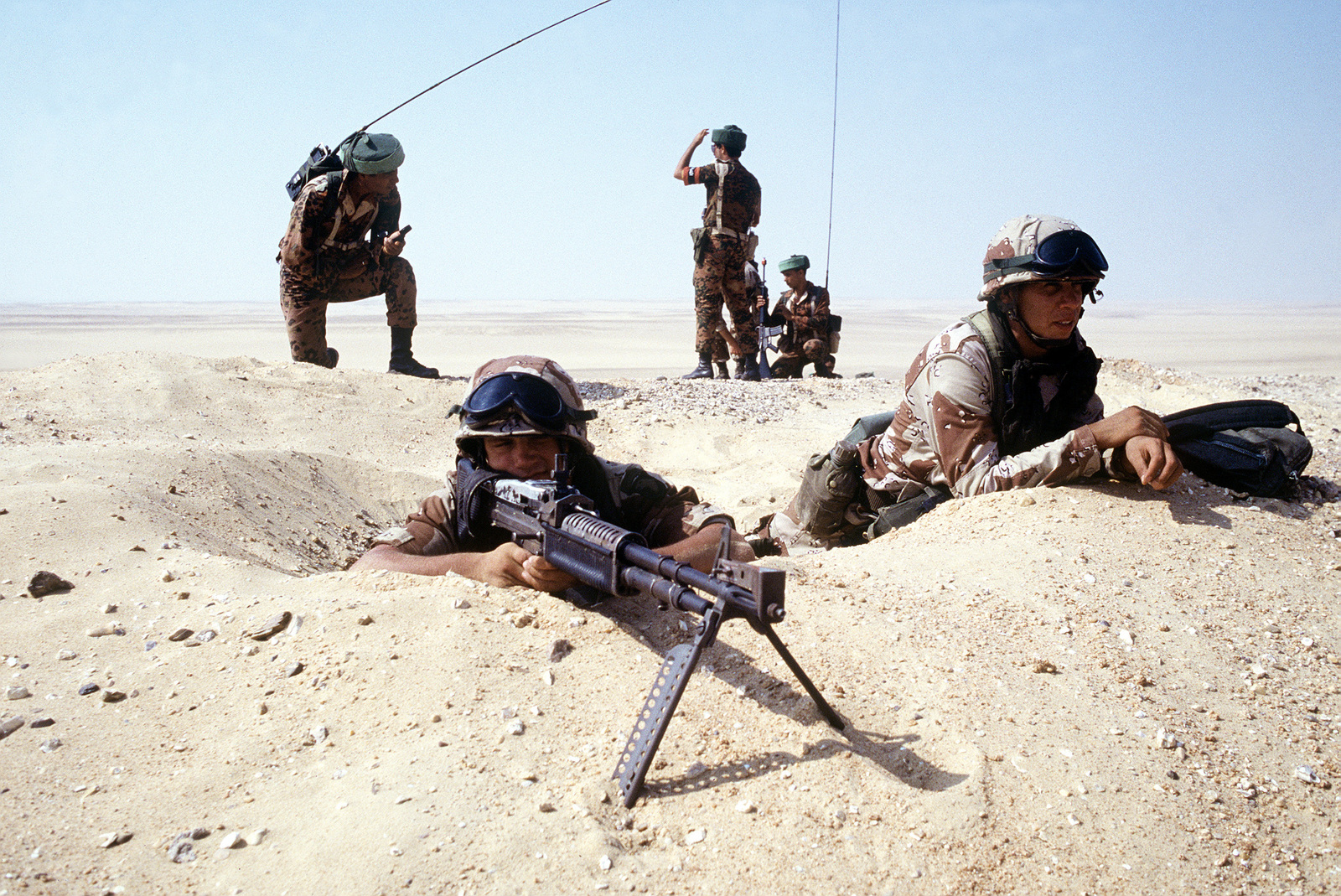 Zwei Soldaten der US-Armee in einem Fuchsloch in der Wüste, einer mit einem...