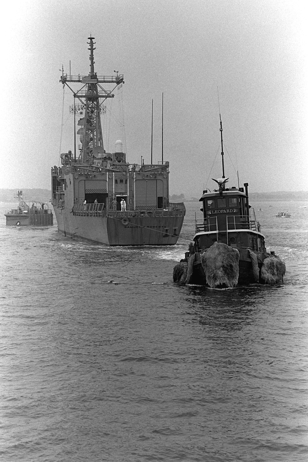 A Harbor Tug Assists The Guided Missile Frigate USS SAMUEL B. ROBERTS ...