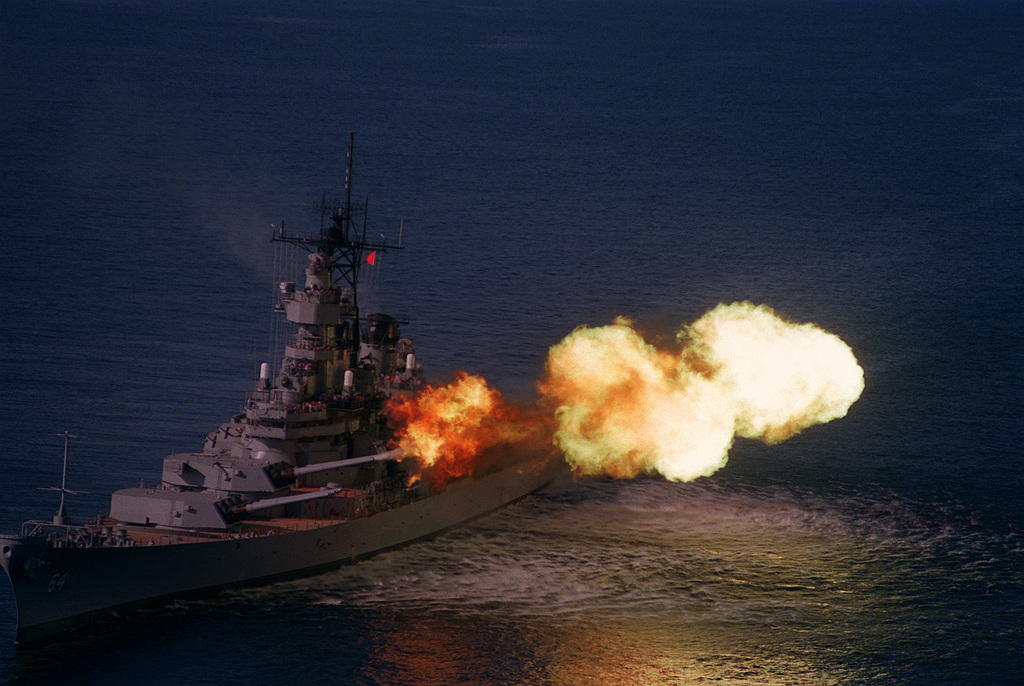 A port bow view of the battleship WISCONSIN (BB-64) firing its Mark 7 ...