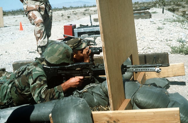 As his partner observes through field glasses, an airman fires an M60 ...