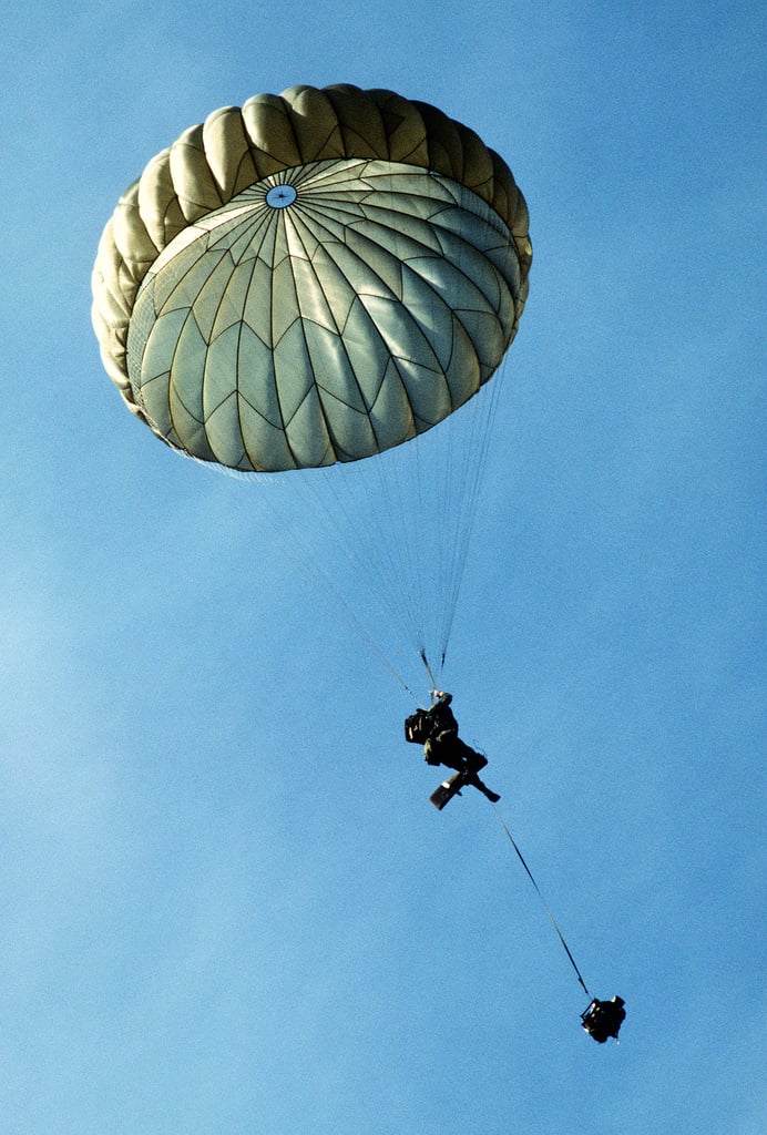 A paratrooper descends with his chute fully deployed, during combined ...