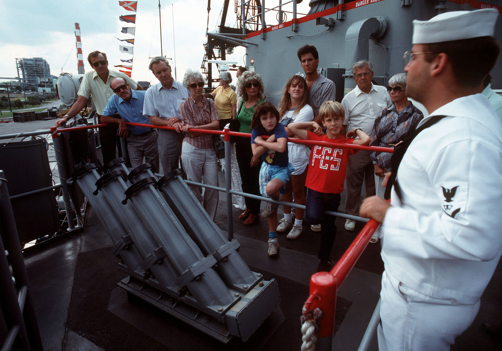 A Sailor Briefs Visitors On Chaff Launchers Aboard The Guided Missile