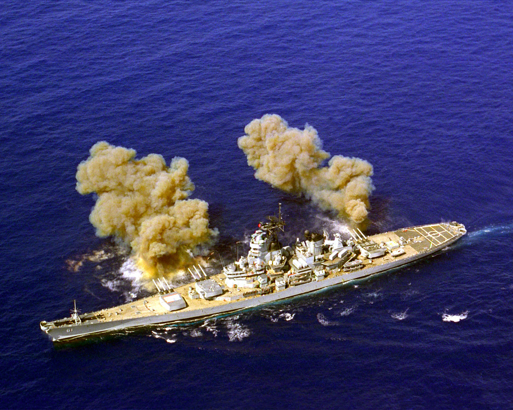 An aerial view of the battleship USS IOWA (BB-61) firing its Mark 7 16 ...