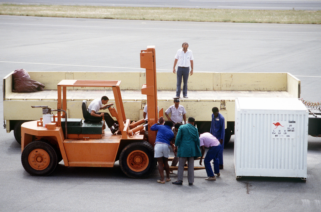 Airport Workers Adjust The Forks On A Forklift Before It Is Used To Place A Container In The Bed Of A Truck The Container Holds Some Of The Equipment Brought By A United Nations Sponsored Assistance Group The Group Made Up Of 28 Civil Engineers From Two