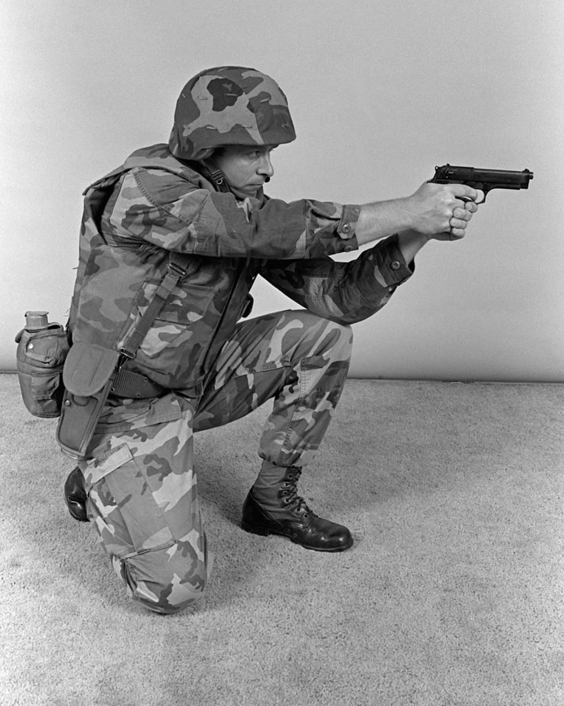 A Marine Demonstrates A Kneeling Firing Position With An M 9 9mm Pistol