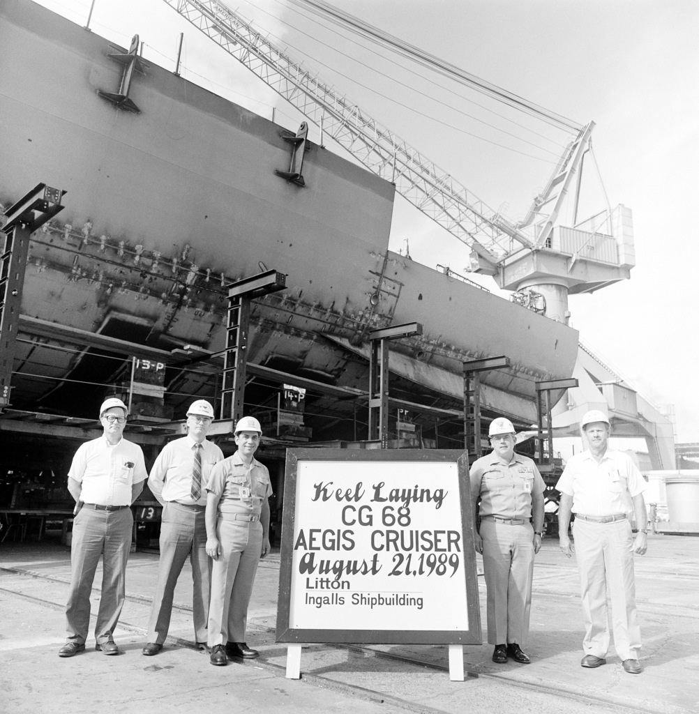 Representatives of Ingalls Shipbuilding and the U.S. Navy stand by a