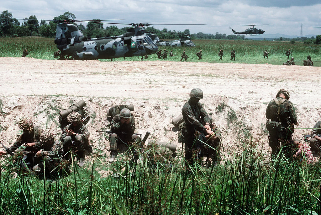 Marines unpack their gear as two CH-46E Sea Knight helicopters of ...