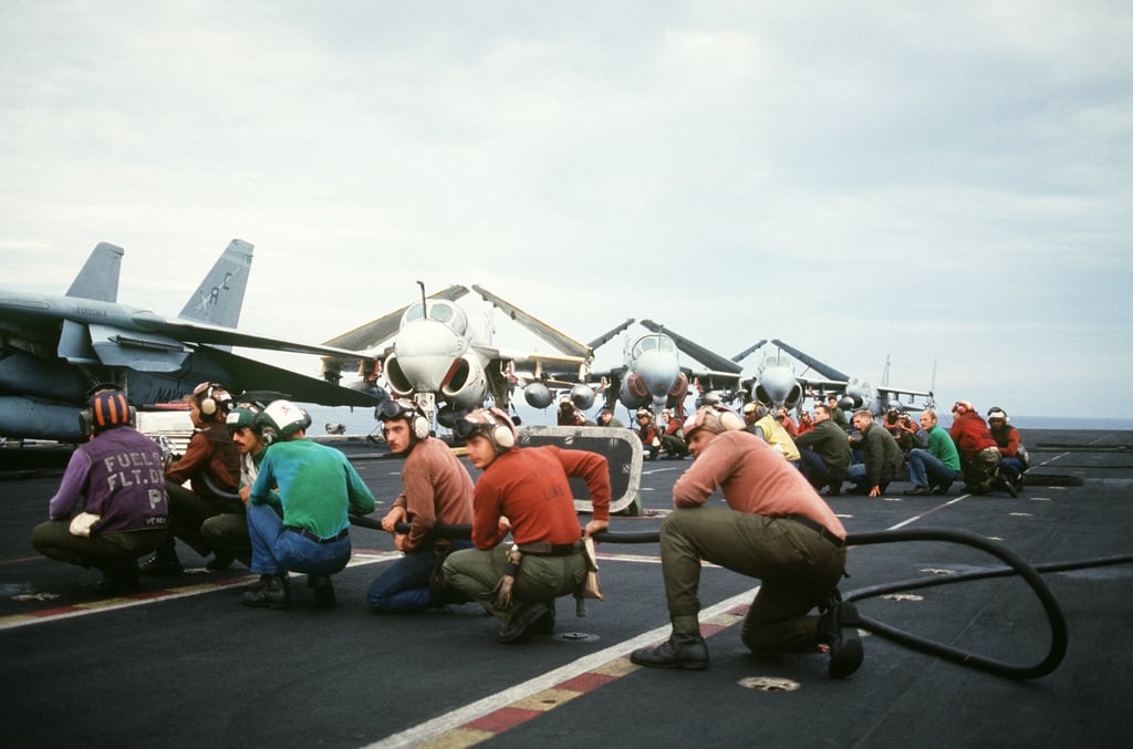 Flight deck crewmen go through a firefighting drill aboard the Aircraft ...