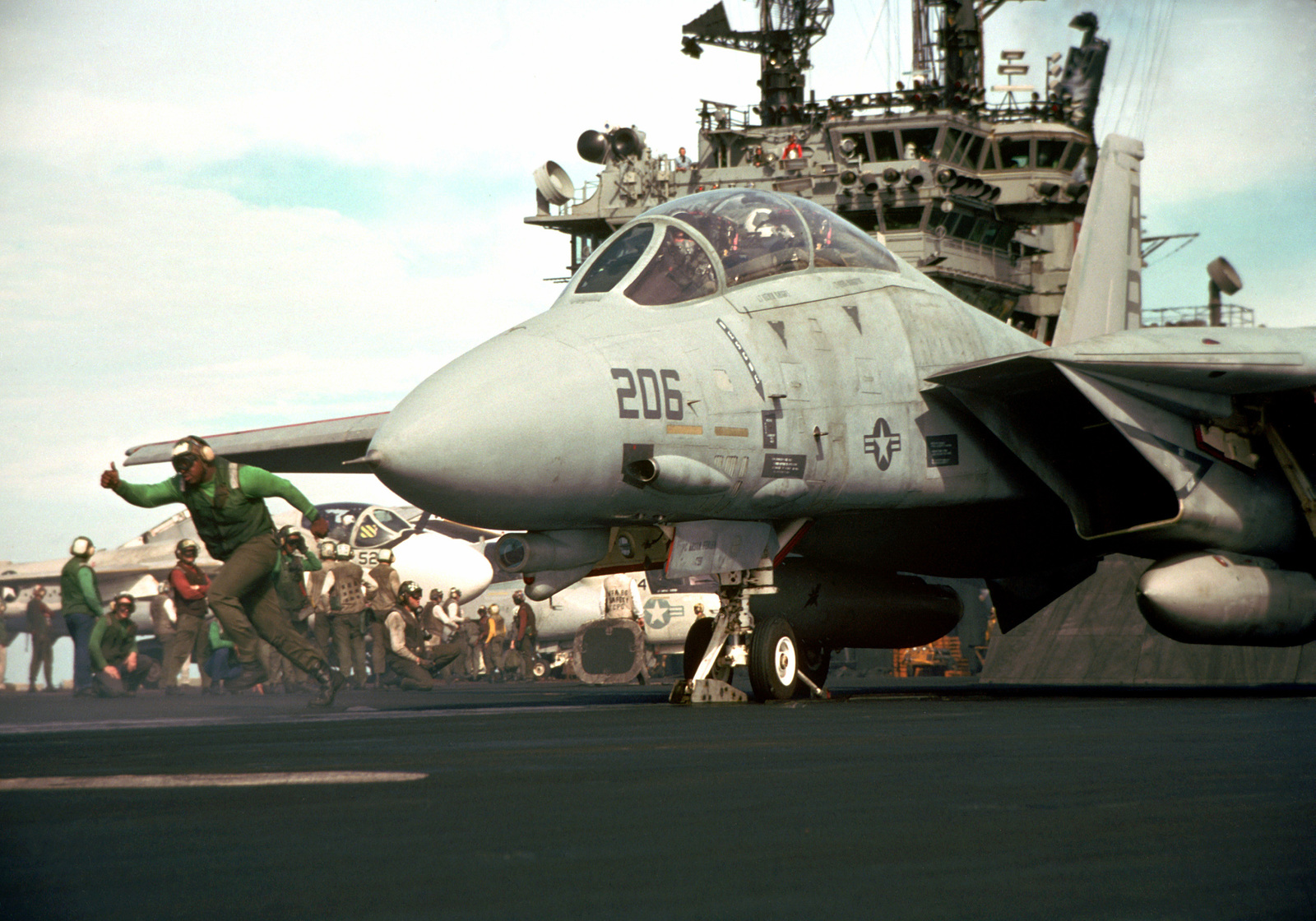 A catapult crewman moves out of the way after a final pre-launch check ...