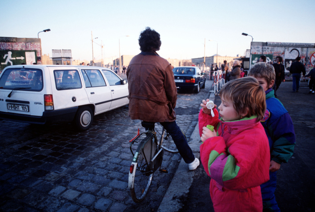 a-child-blows-bubbles-at-the-passing-traffic-as-cars-move-between-east