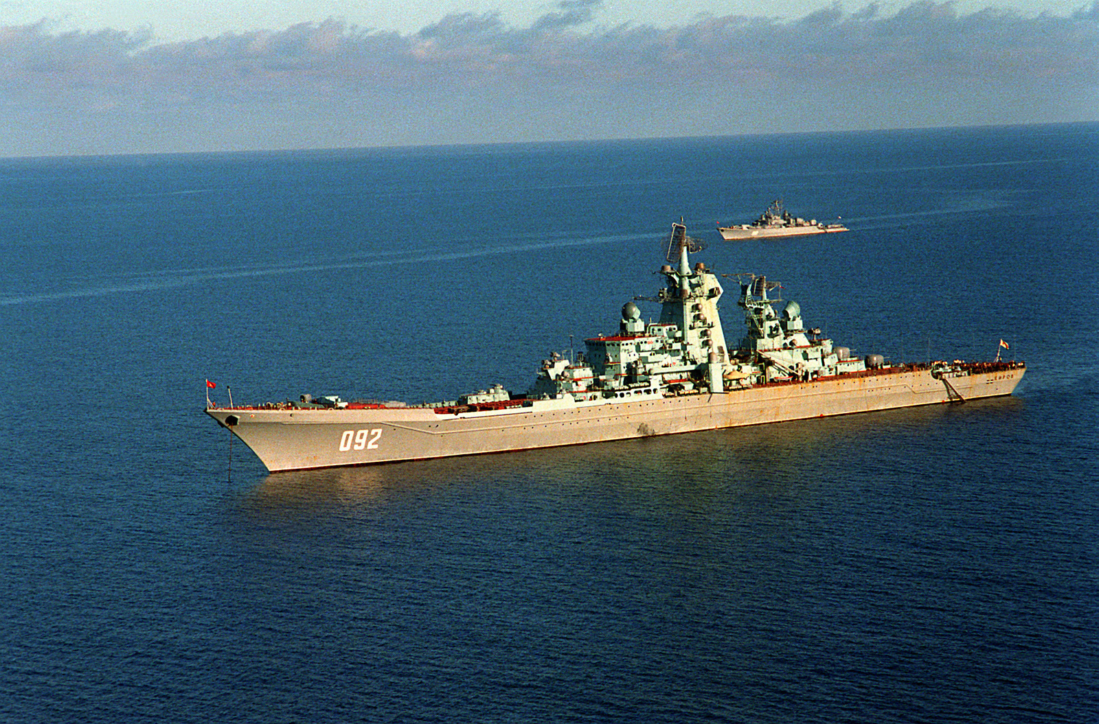 A port view of the Soviet nuclear-powered guided missile cruiser KIROV at anchor. In the background is a Soviet Krivak I-class guided missile frigate