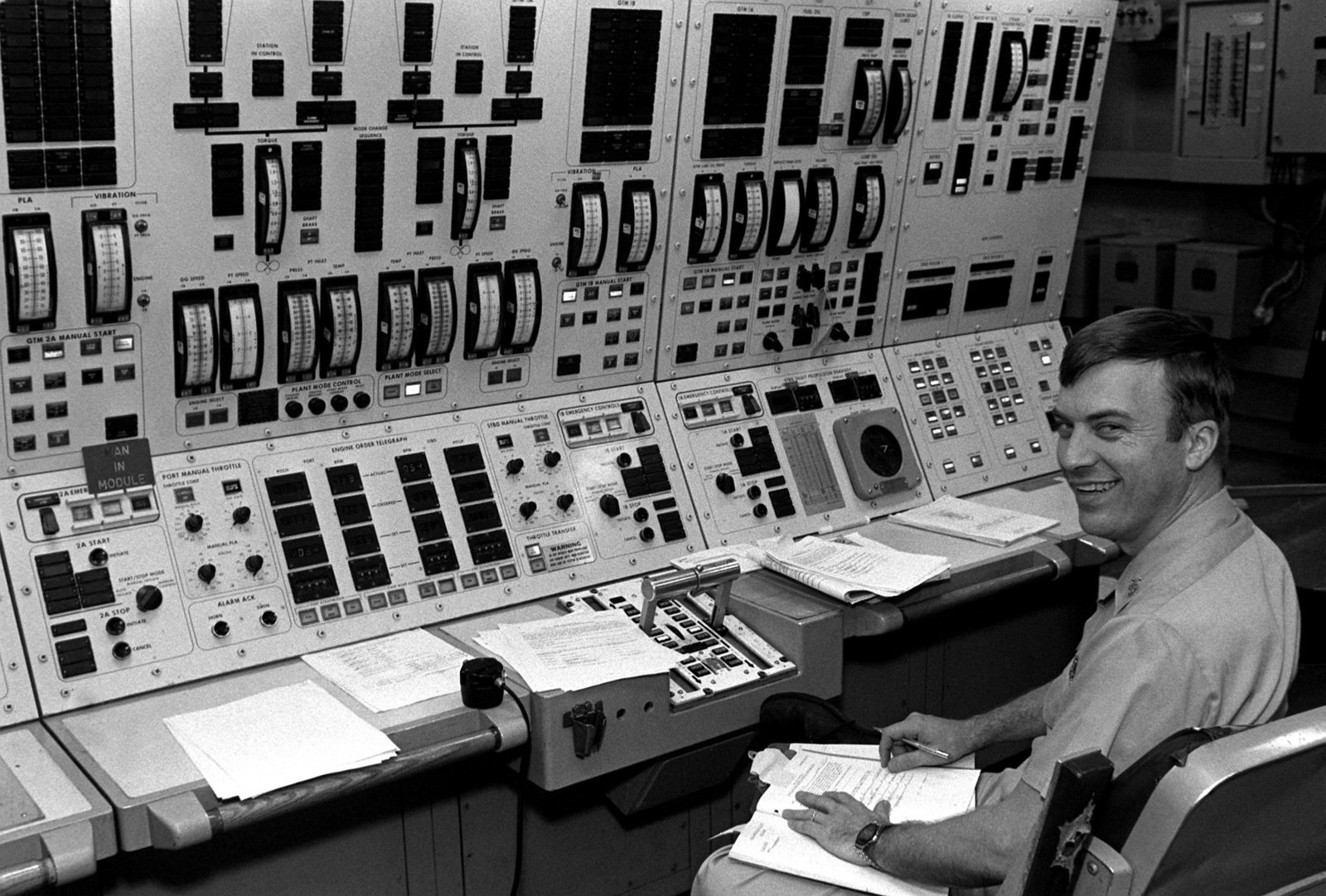 A crew member works at engine control panels in the central control ...