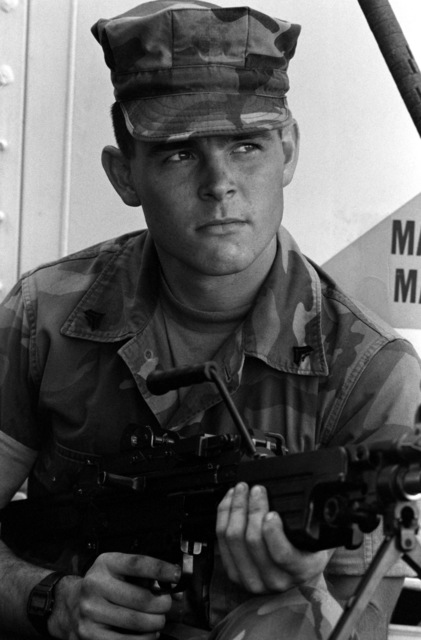 A Marine corporal holds his M-249 squad automatic weapon while embarked ...