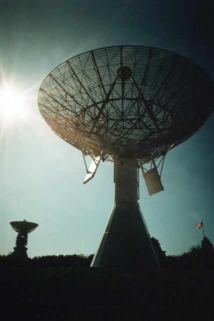 A view of the KENNEDY, foreground, and Aeronica 60-foot parabolic ...