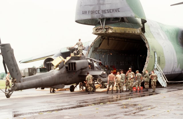 Personnel from the 82nd Airborne Division load an AH-64 Apache ...