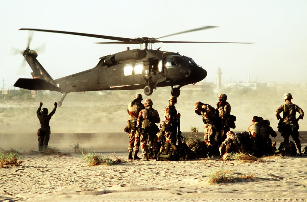 Soldiers stand by to board a UH-60A Black Hawk (Blackhawk) helicopter ...