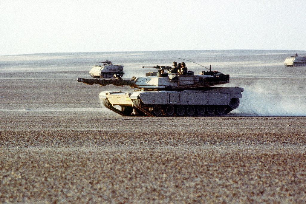 An M-1 Abrams main battle tank, foreground, and M-113 armored personnel ...