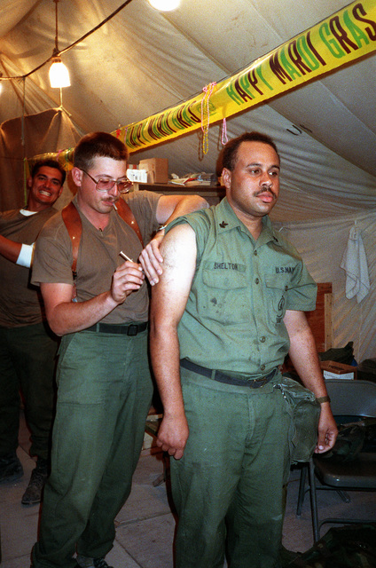 A Seabee from Naval Mobile Construction Battalion 5 (NMCB-5) receives ...