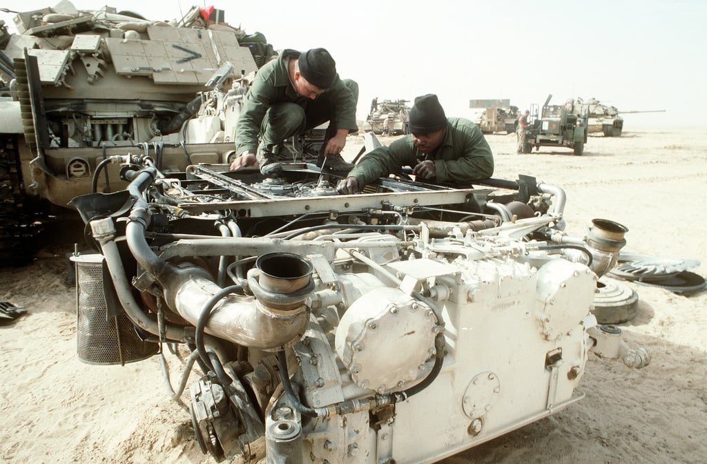 Marines gather beside an M-60A1 main battle tank fitted with