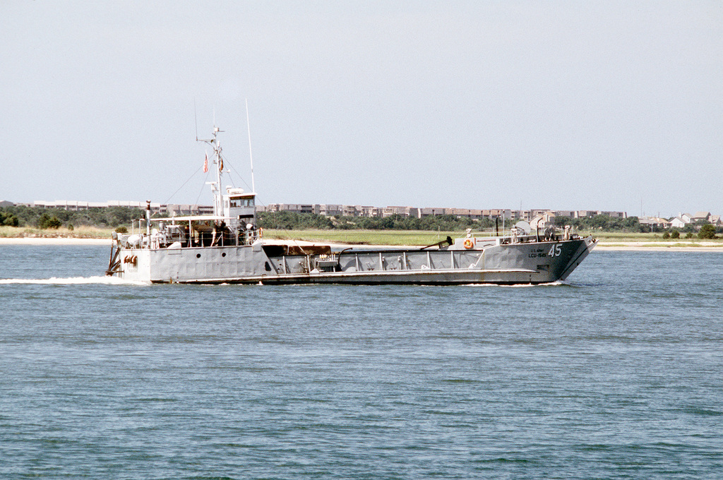 A U.S. Marine throws a rope as they approach a landing craft utility boat  during combat