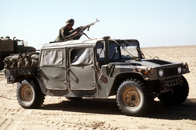 A Marine stands behind an M-60E3 machine gun placed on the roof of an ...