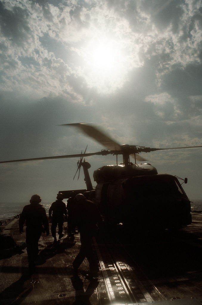 An SH-60B Sea Hawk helicopter is secured for refueling on the flight ...