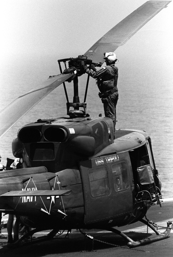 A crewman inspects the rotor assembly of a UH-1N Iroquois helicopter on ...