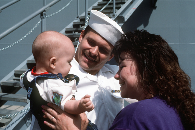 A sailor from the destroyer tender USS ACADIA (AD-42) is reunited with ...