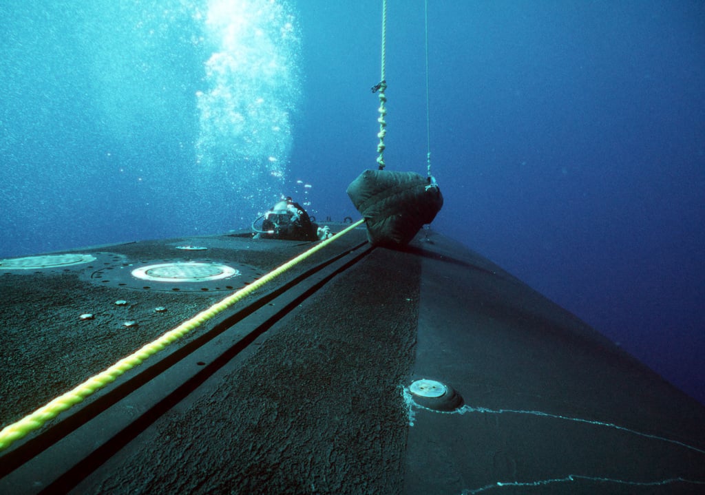 A Member Of A Navy Sea-air-land (seal) Team Emerges From The Hull Of A 