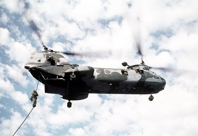 A Marine slides down a rope suspended from a Marine Medium Helicopter ...