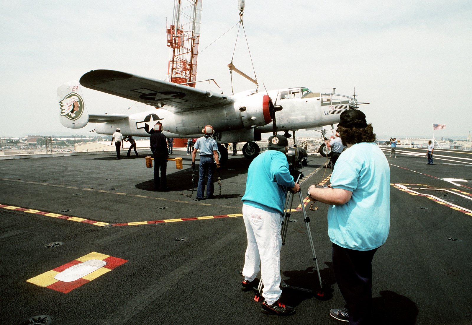 A Crane Sets A Restored B-25 Mitchell Bomber Aircraft On The Deck Of ...