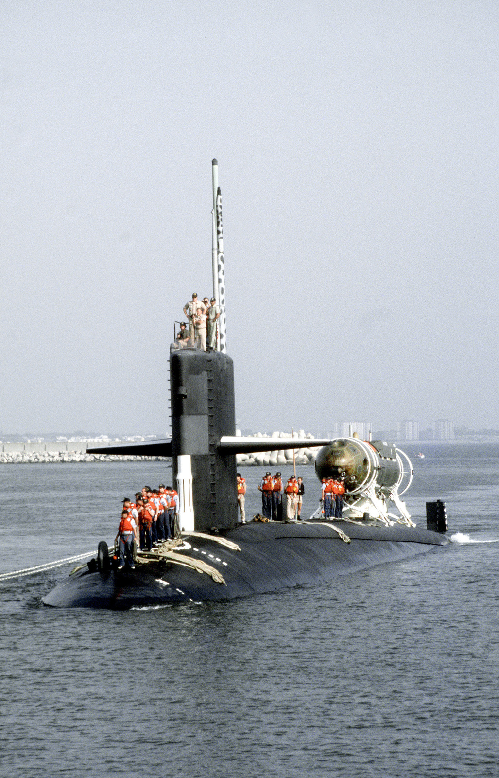 Crewmen stand ready on the deck of the nuclear-powered attack submarine ...