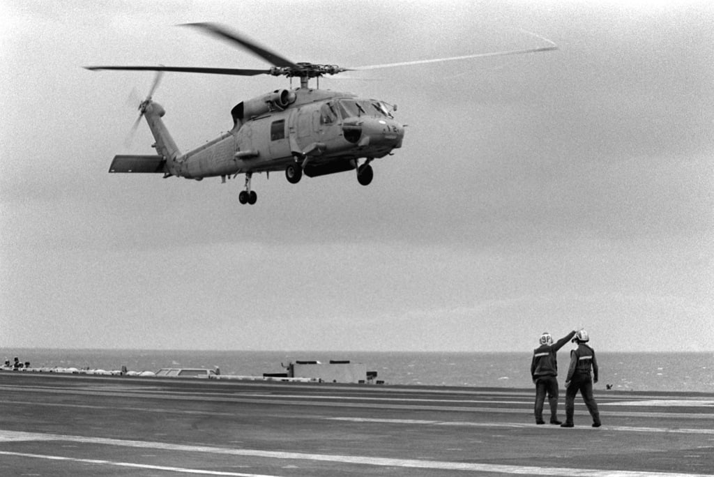 Flight deck crewmen watch as a Helicopter Anti-submarine Squadron 2 (HS ...