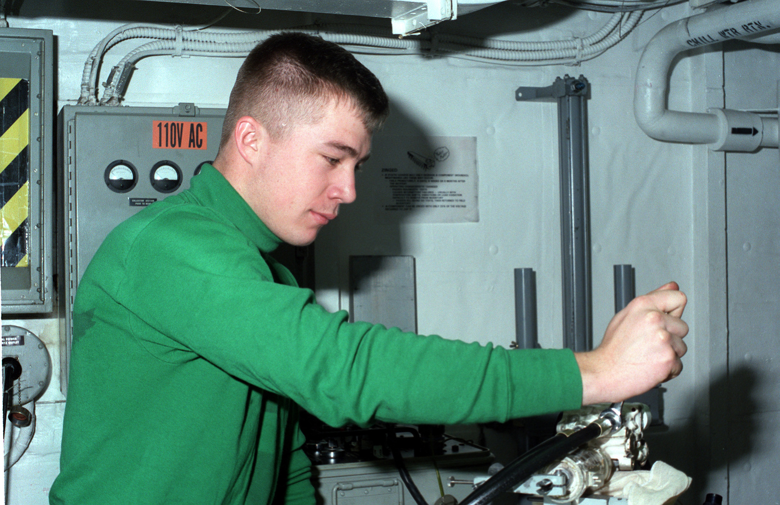 a-crewman-works-in-a-repair-shop-aboard-the-nuclear-powered-aircraft