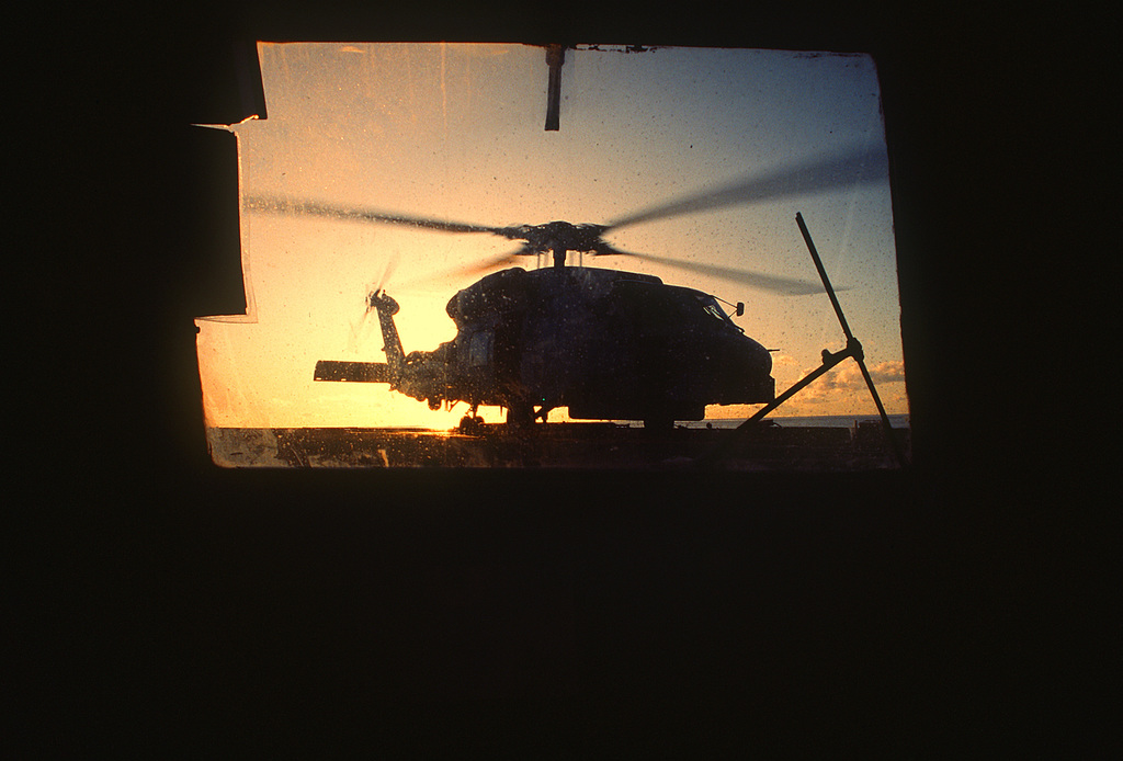 A Sunrise View Of A Sh 60 Seahawk Helicopter Parked On The Flight Deck Of The Guided Missile 