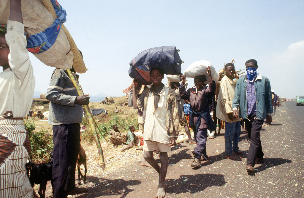 A stream of Rwandan refugees, carrying all their possession, walk into ...