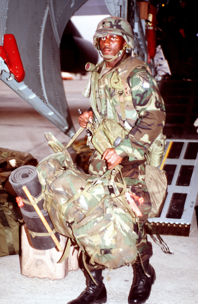 A soldier from 10th Mountain Division unloads his equipment off a