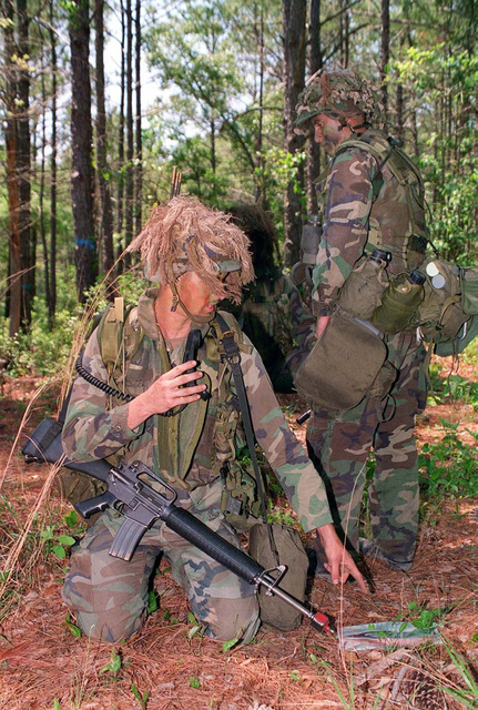 Lance CPL. Mike Engelend, dressed in camouflage gear, takes a look at a ...