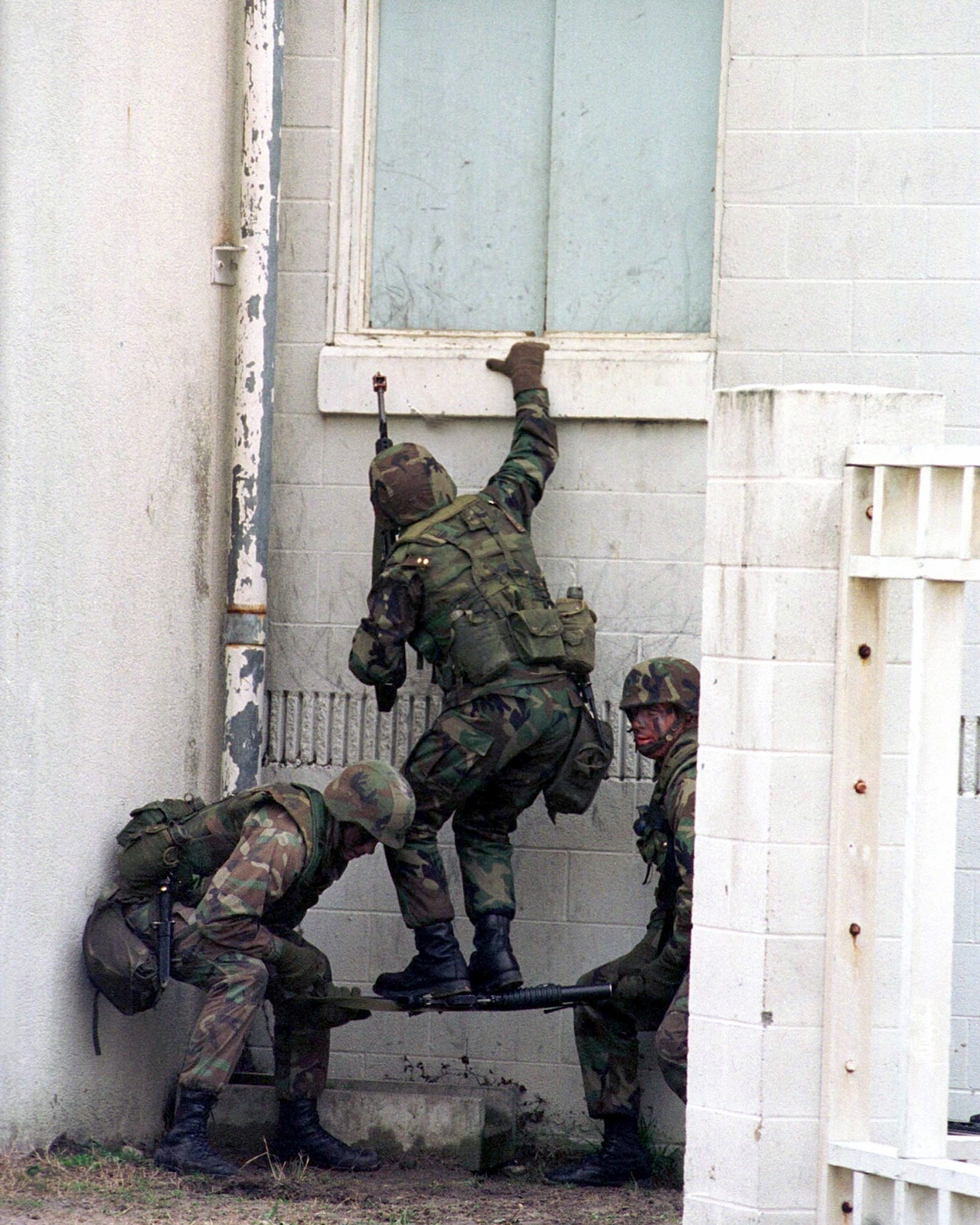 Using an M16A2 as a step, Marines from India Company, 3rd Battalion, 2d ...